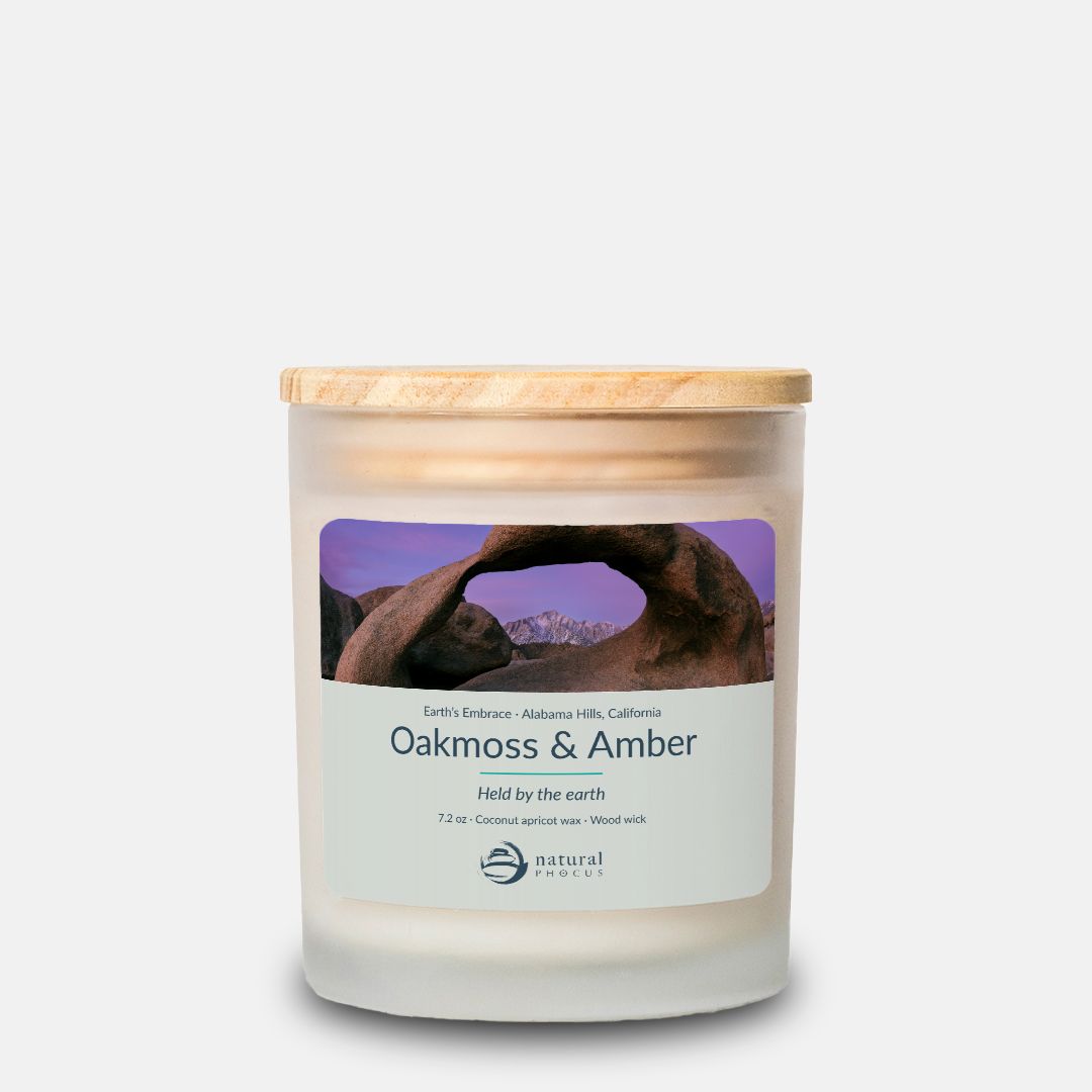 Earth’s Embrace Candle in Oakmoss and Amber, a frosted glass candle with a maple wood lid, labeled with a photograph of Mobius Arch framing the snow-covered Sierra Nevada at dawn in the Alabama Hills, California