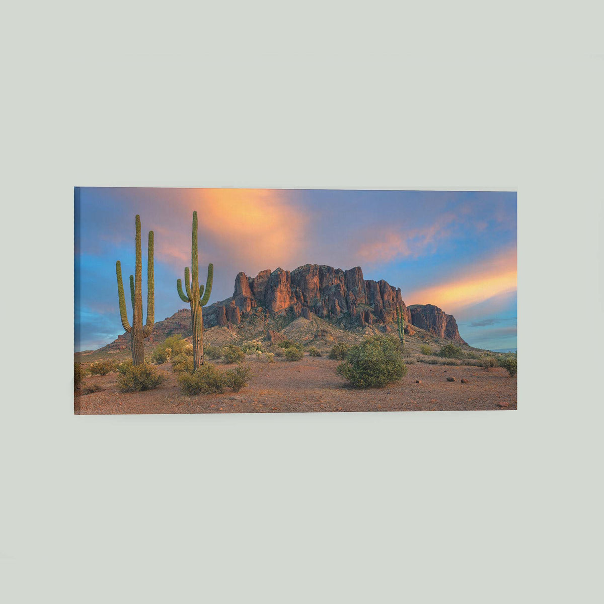 The Gold Was Always Here, saguaro cacti before the Superstition Mountains glowing at sunset in Arizona, as a stretched canvas shown at an angle