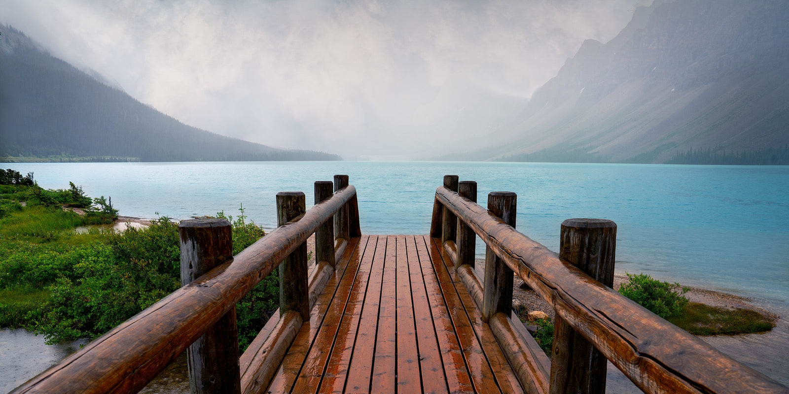 Wooden bridge leading into fog over Bow Lake, Banff National Park