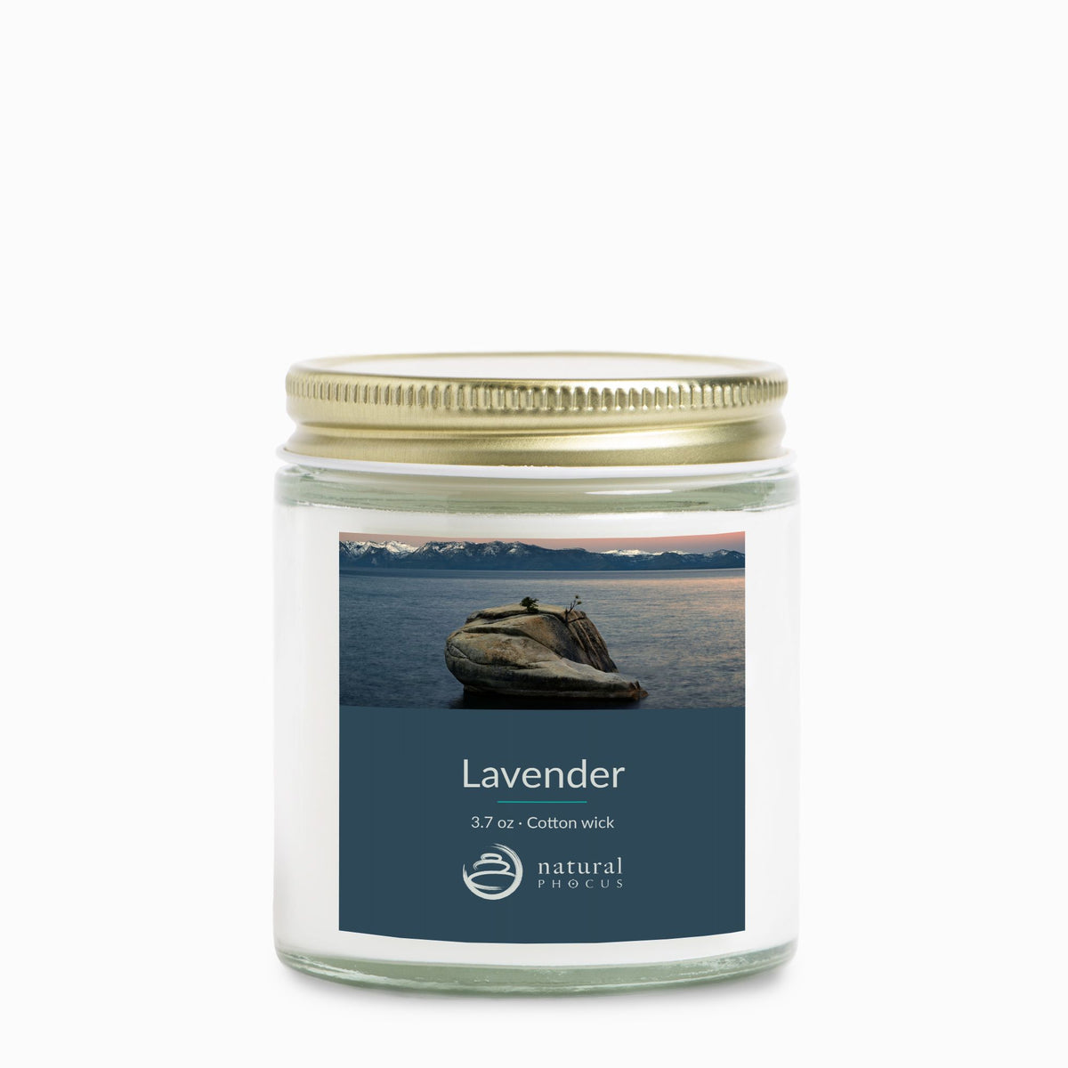 The Heart of Lake Tahoe Mini Candle in Lavender, a 4 oz clear glass jar candle with a gold lid, labeled with a photograph of Bonsai Rock in still water beneath snow-covered peaks at Lake Tahoe, Nevada