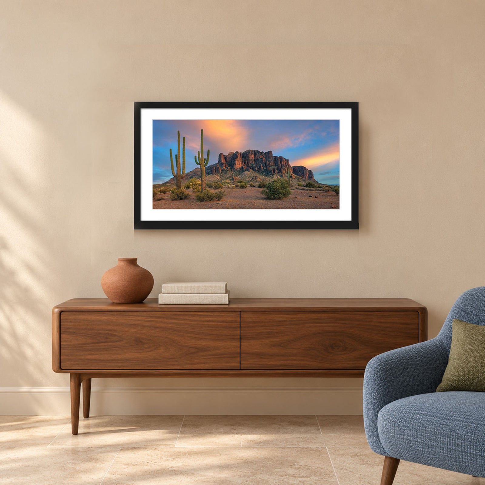 The Gold Was Always Here, saguaro cacti before the Superstition Mountains glowing at sunset in Arizona, in a black frame shown in a home setting