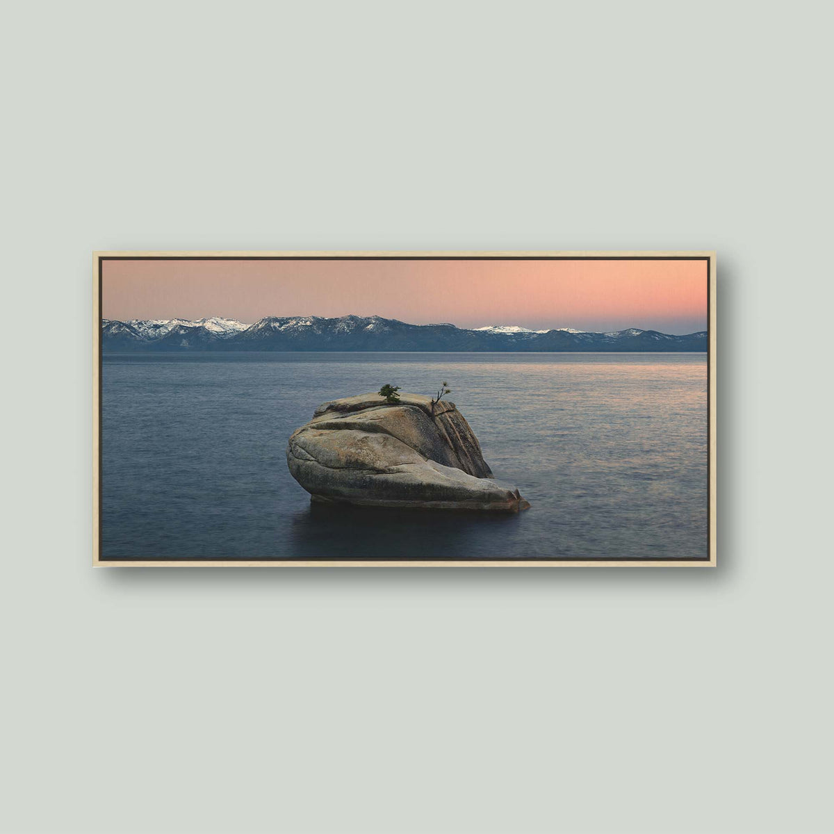 The Heart of Lake Tahoe, a solitary rock with a small tree rising from the still water of Lake Tahoe at sunrise, as a canvas in a maple floating frame