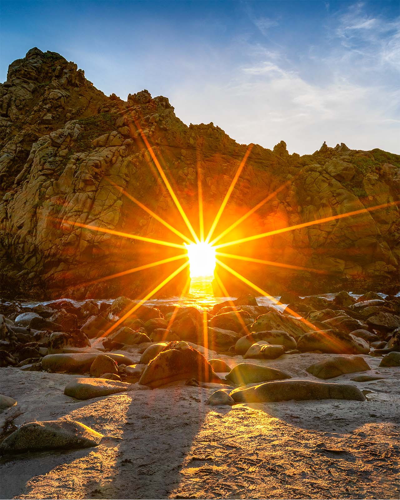 Sunset light streaming through Keyhole Arch at Pfeiffer Beach, Big Sur, California, photographed by Steve Austin