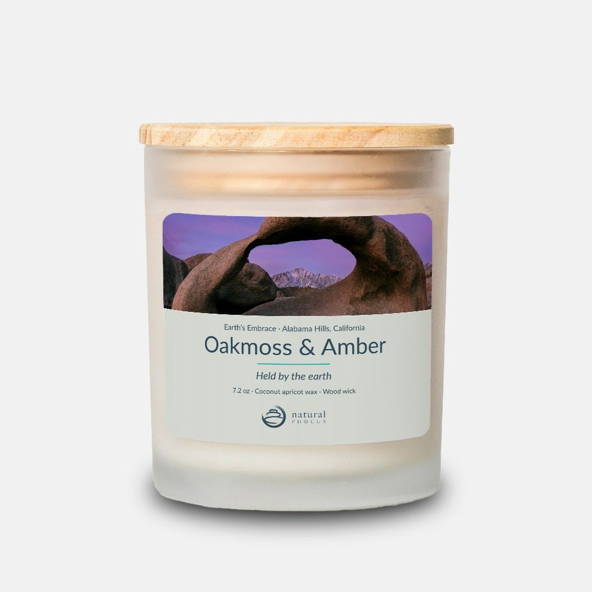 Earth’s Embrace Candle in Oakmoss and Amber, a frosted glass candle with a maple wood lid, labeled with a photograph of Mobius Arch framing the snow-covered Sierra Nevada at dawn in the Alabama Hills, California