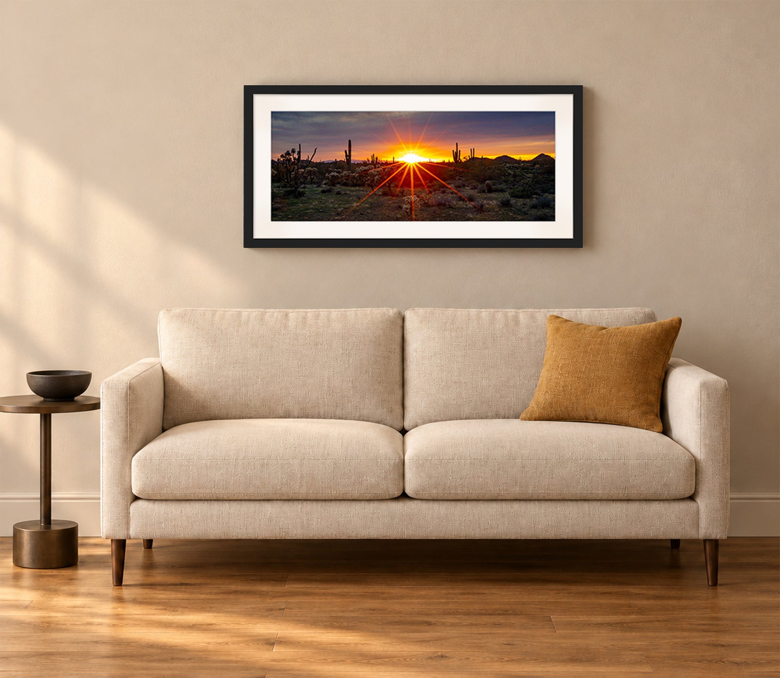 Where the Desert Exhales, a sunset sunburst over saguaro and cholla cacti in the Sonoran Desert of Arizona, in a black frame shown in a home setting