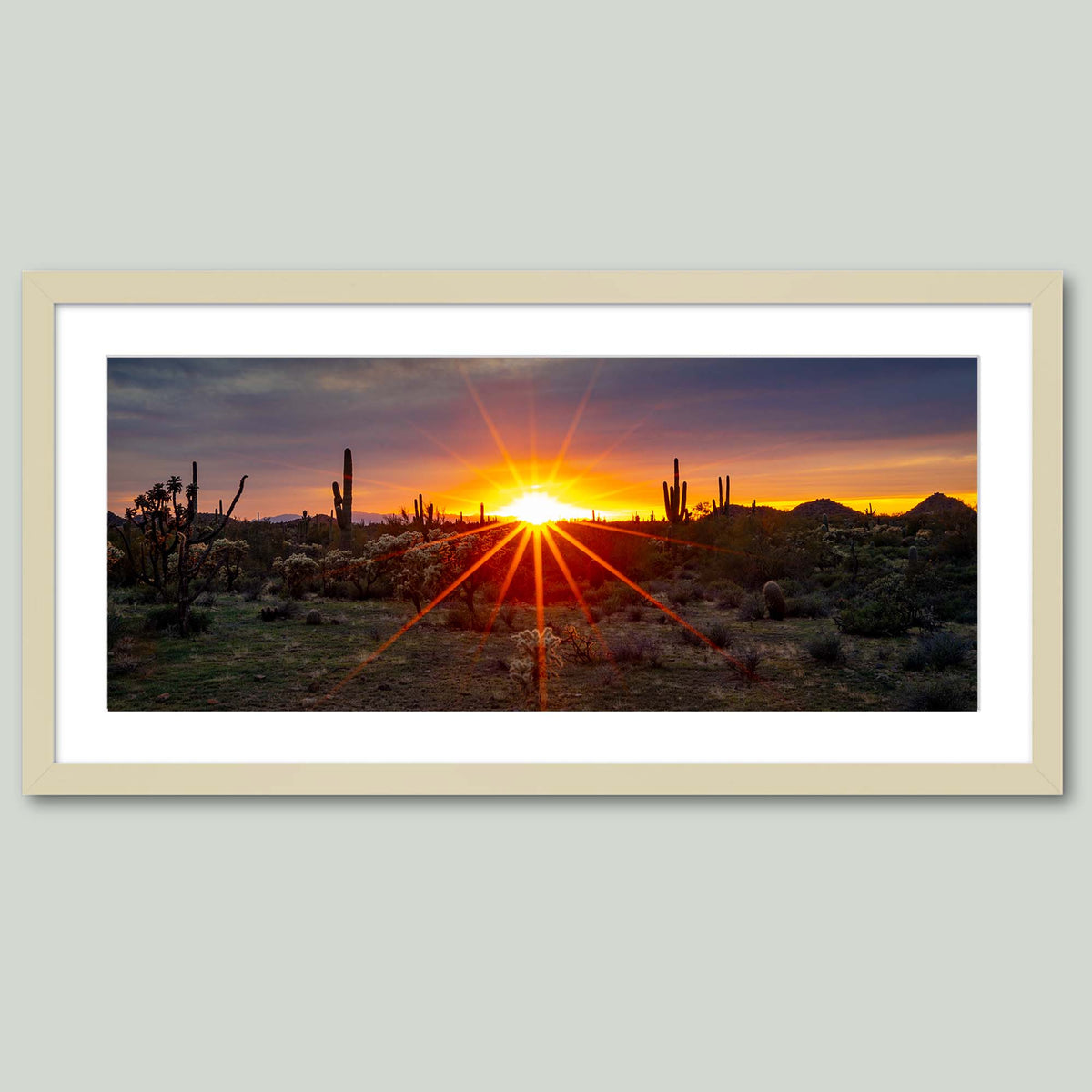 Where the Desert Exhales, a sunset sunburst over saguaro and cholla cacti in the Sonoran Desert of Arizona, in a maple frame with a white mat