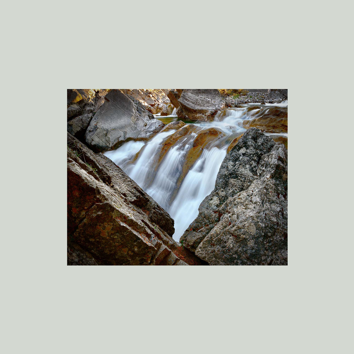 Water Finds a Way, a waterfall flowing between lichen-covered boulders at Hummingbird Falls, Alberta, Canada, as an unframed print